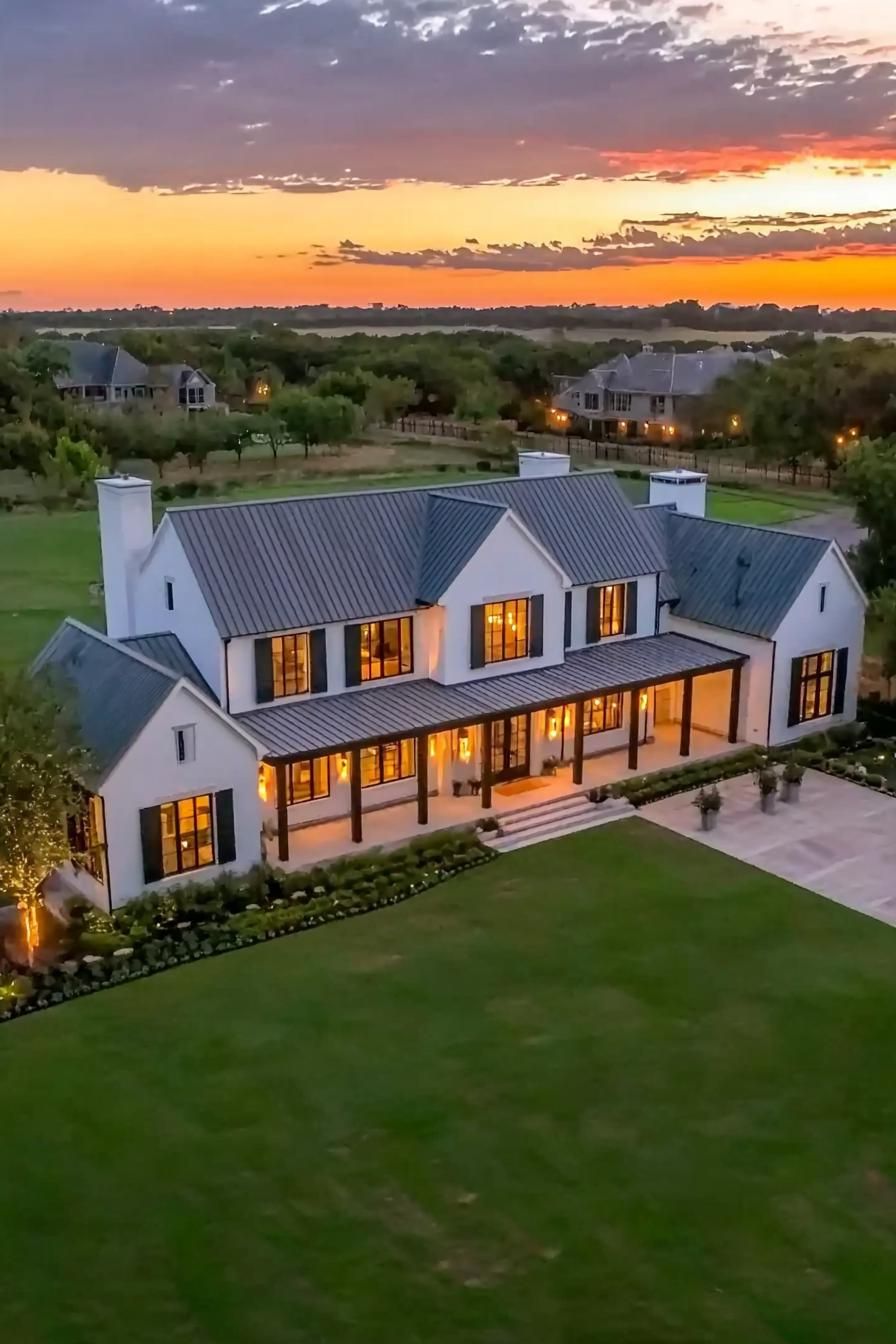 Spacious farmhouse with a large veranda at dusk