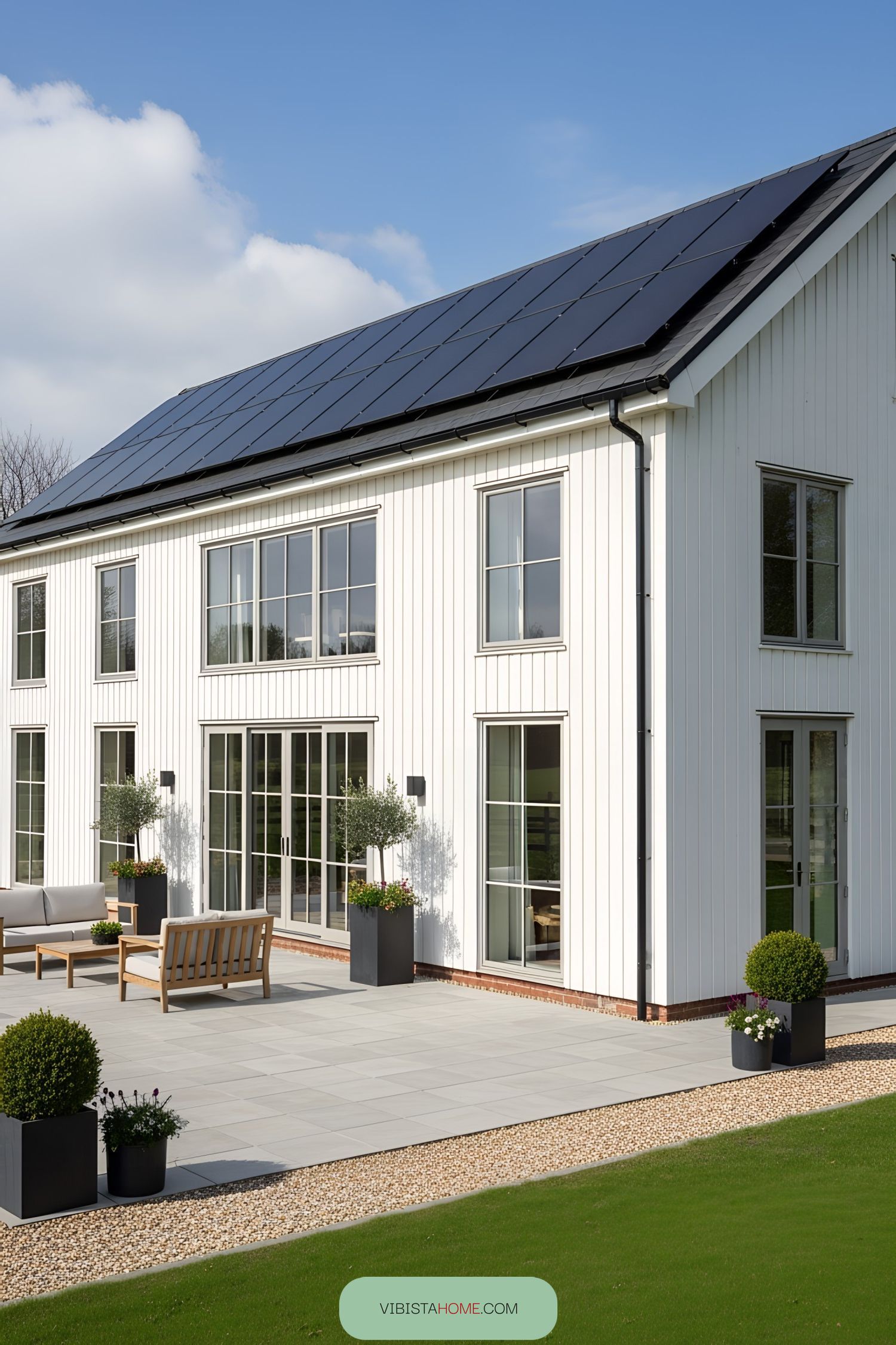 White barn with solar panels and a modern patio