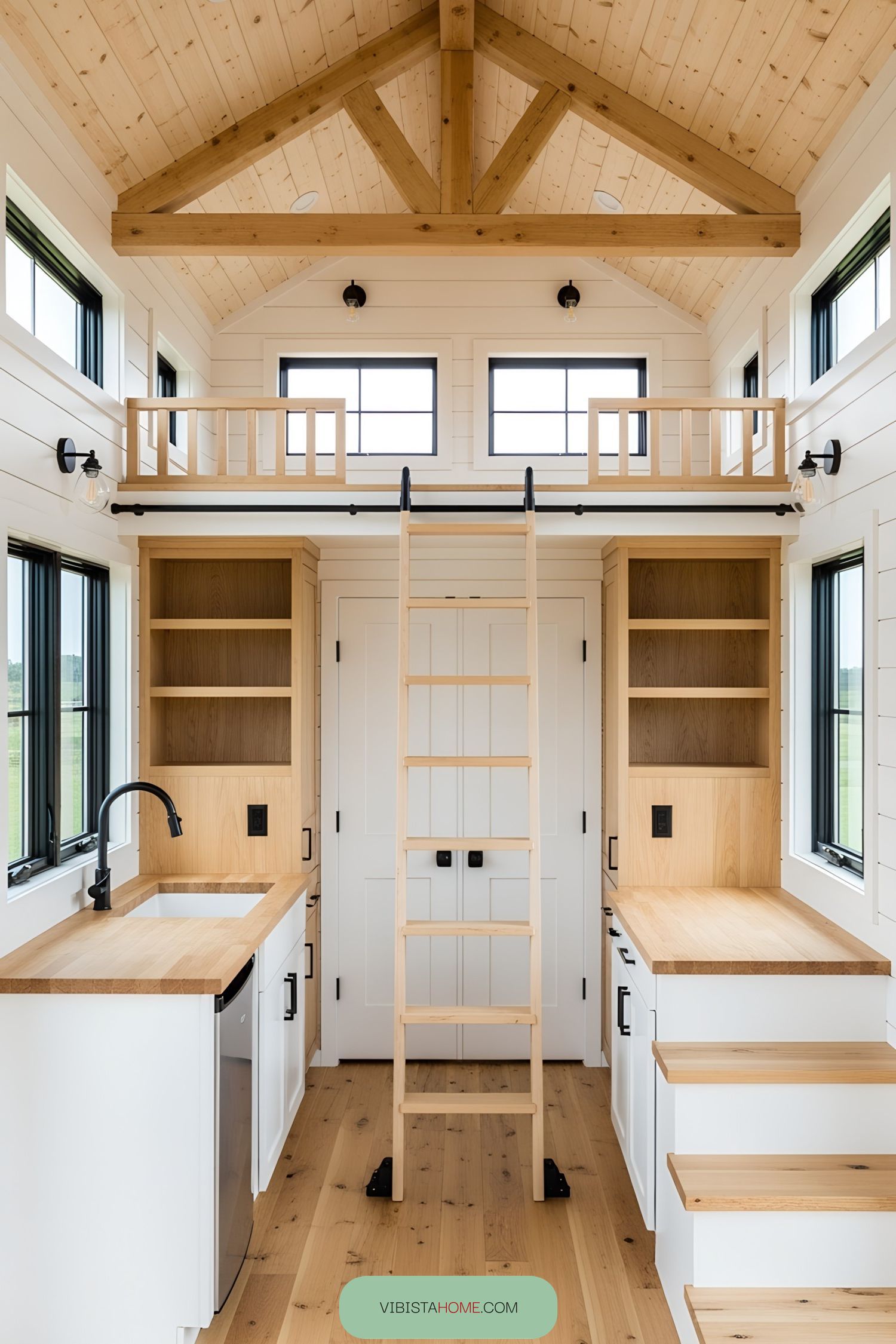 Interior view of a lofted barn tiny house with wooden finishes and a ladder