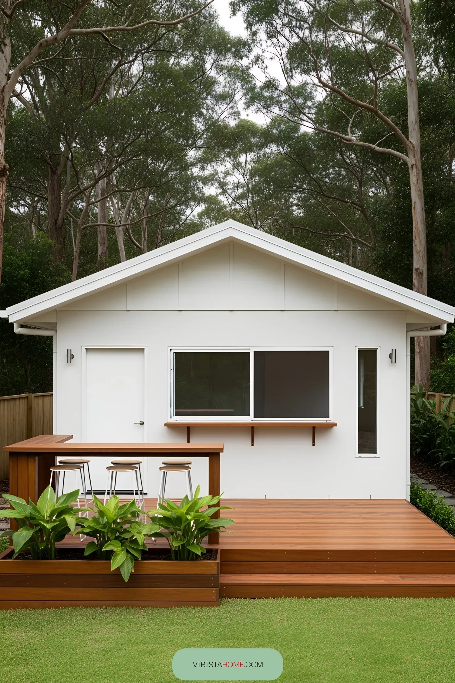 Small white coastal house with a wooden deck