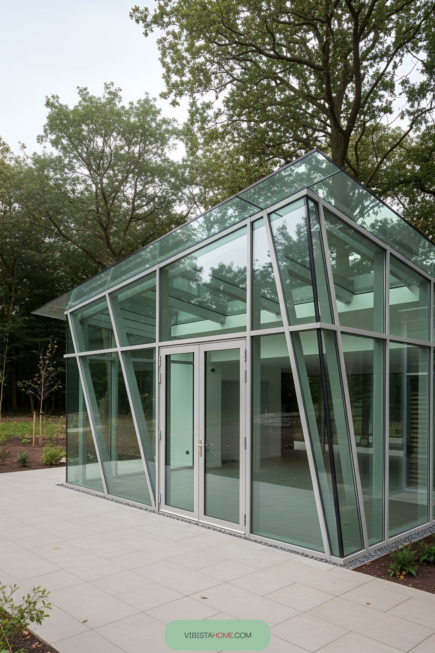 Modern glass structure with angular design in a wooded setting