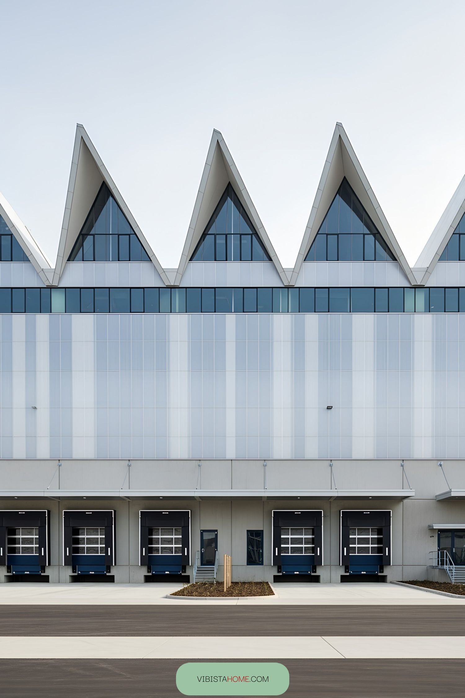 Modern industrial building with triangular roof peaks and loading bays