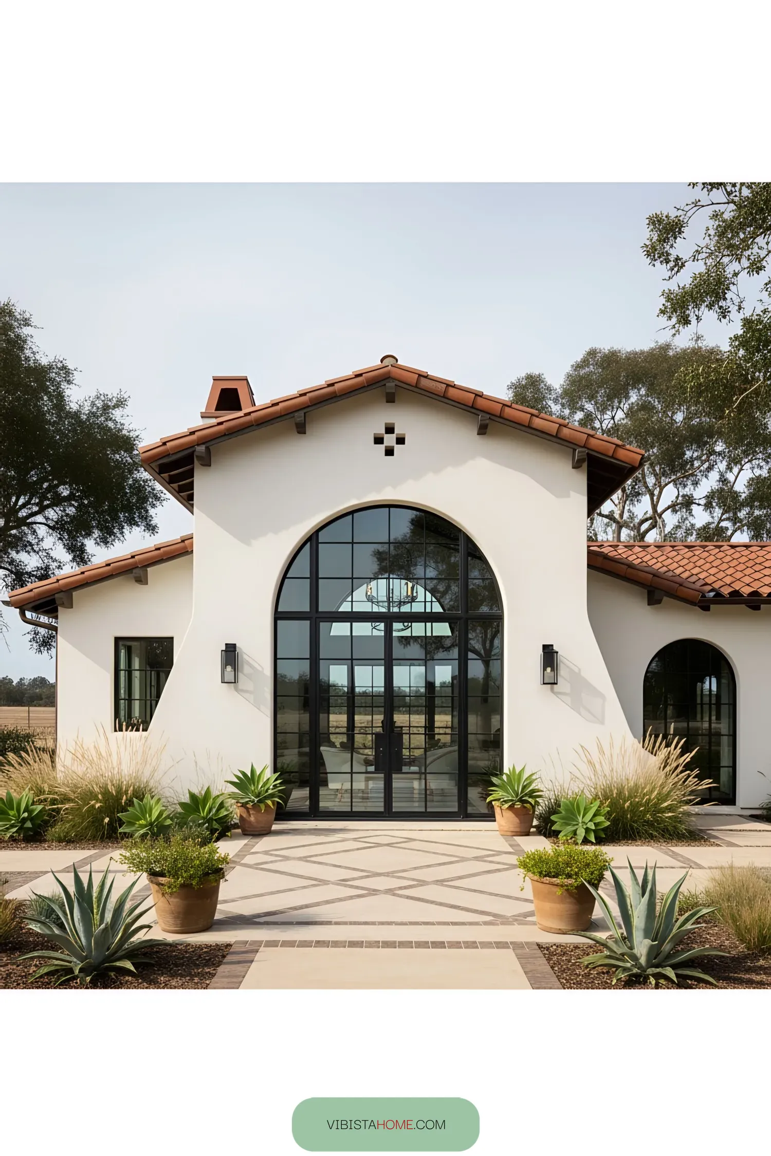Modern Spanish farmhouse with arched windows and terracotta roof