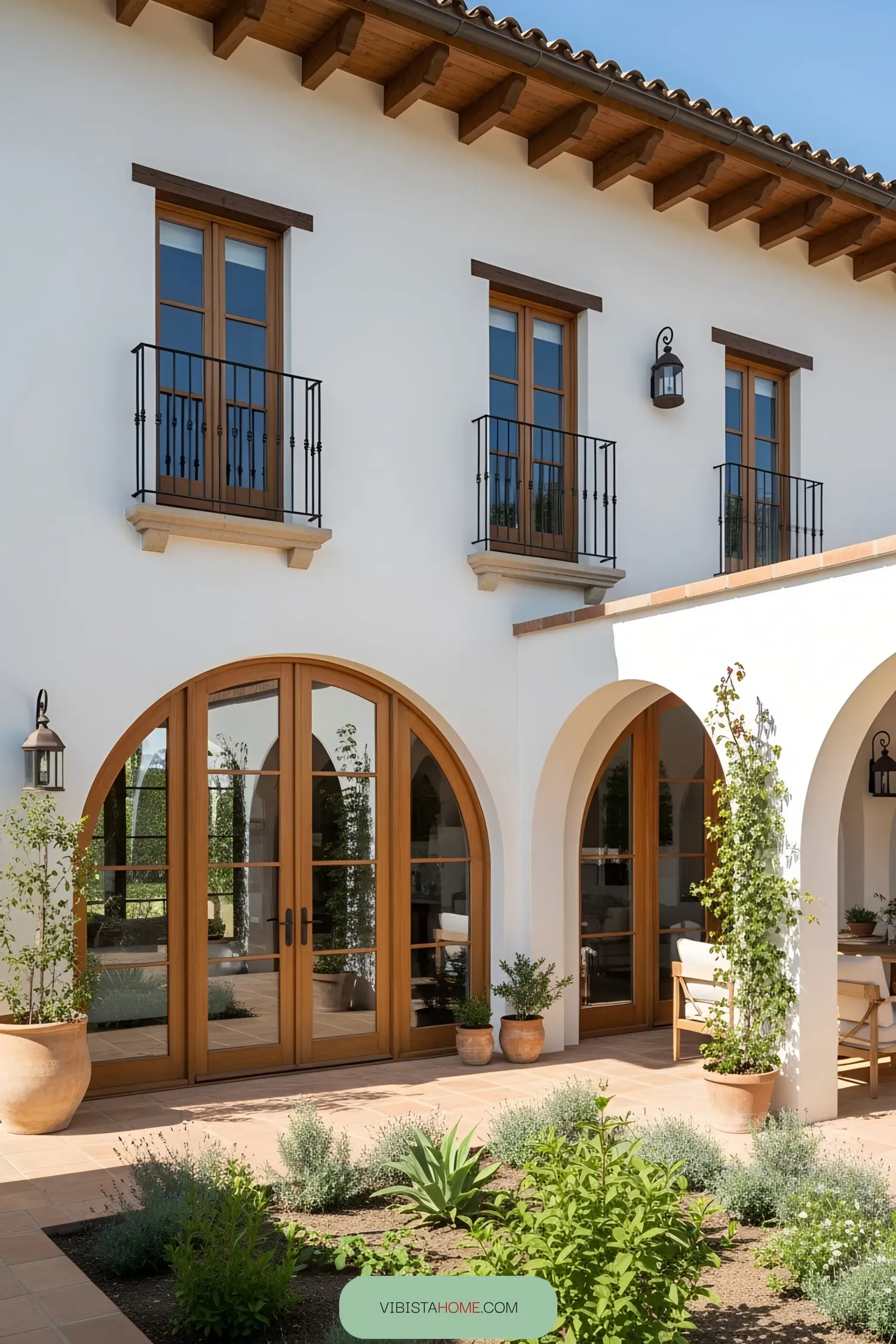 Contemporary Spanish farmhouse with wooden arched doors and balconies