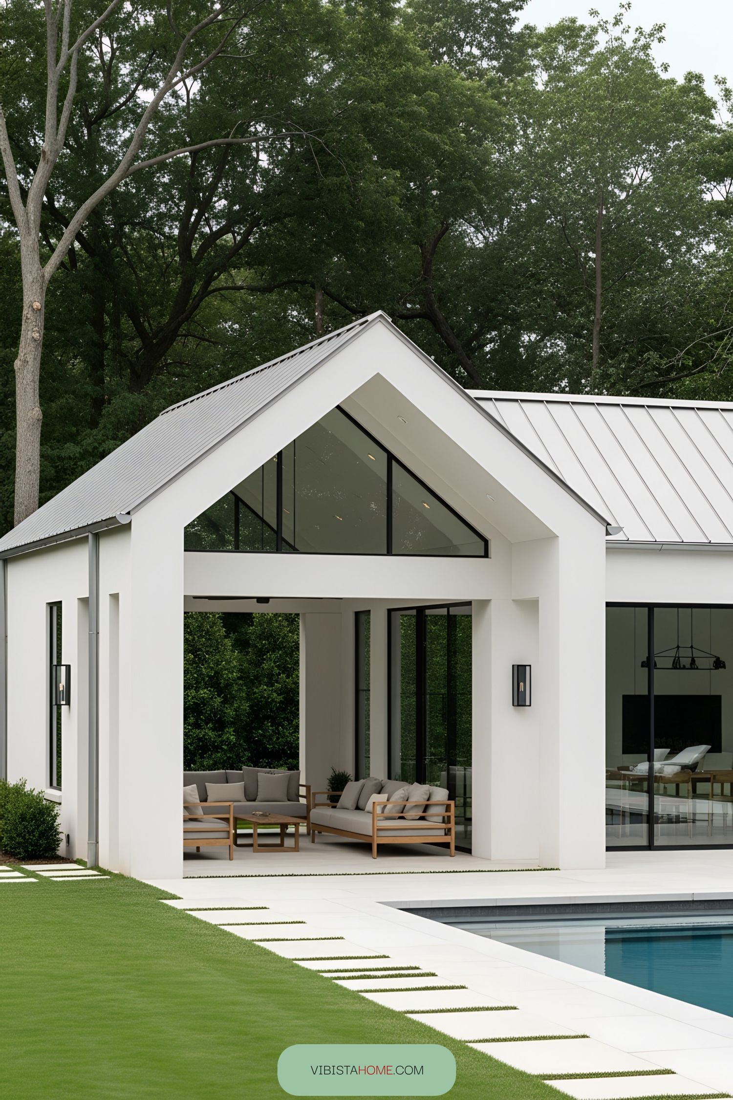 Modern pool house with glass walls and lush greenery