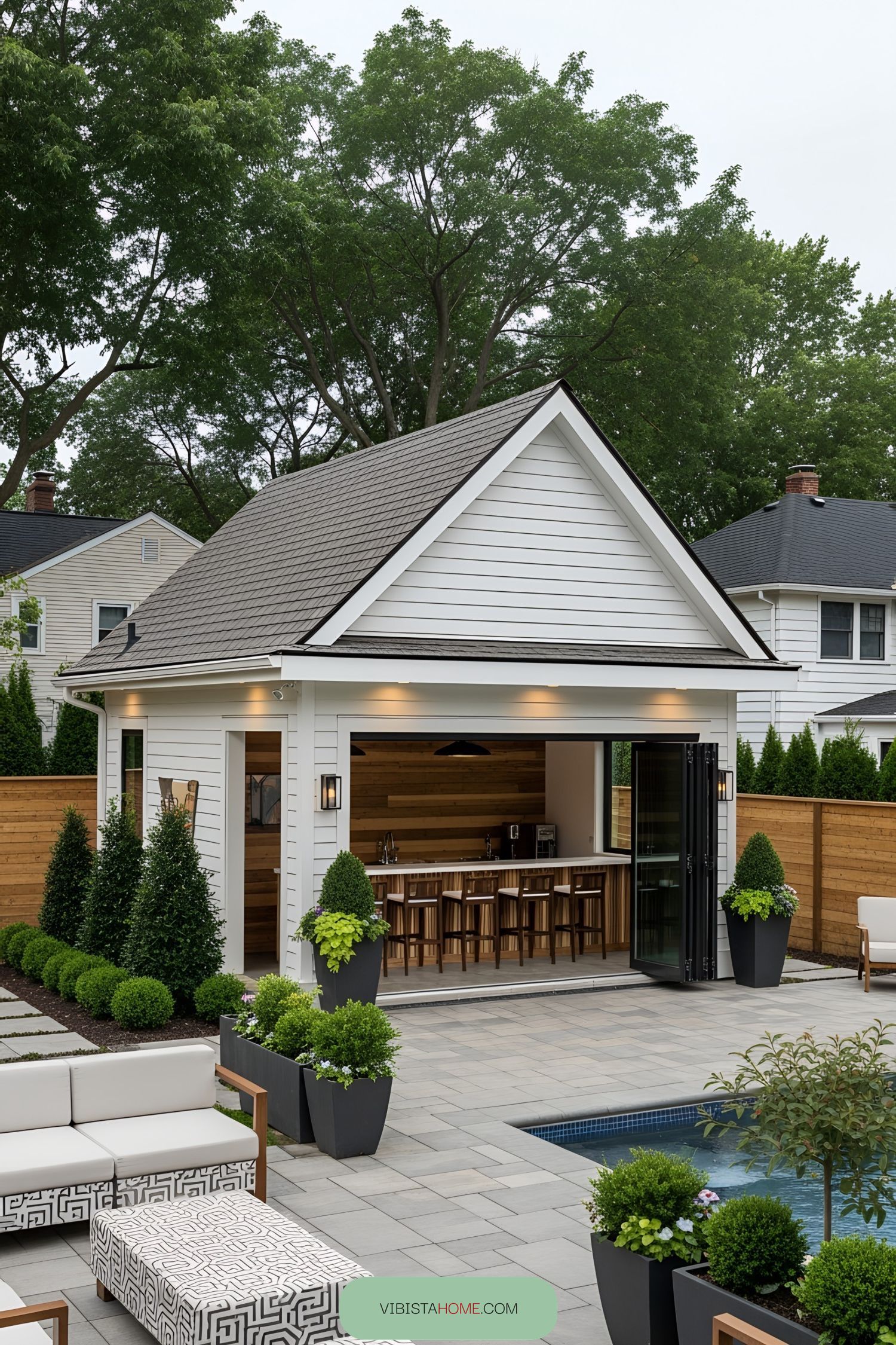 Chic modern pool house with bar seating and lush greenery