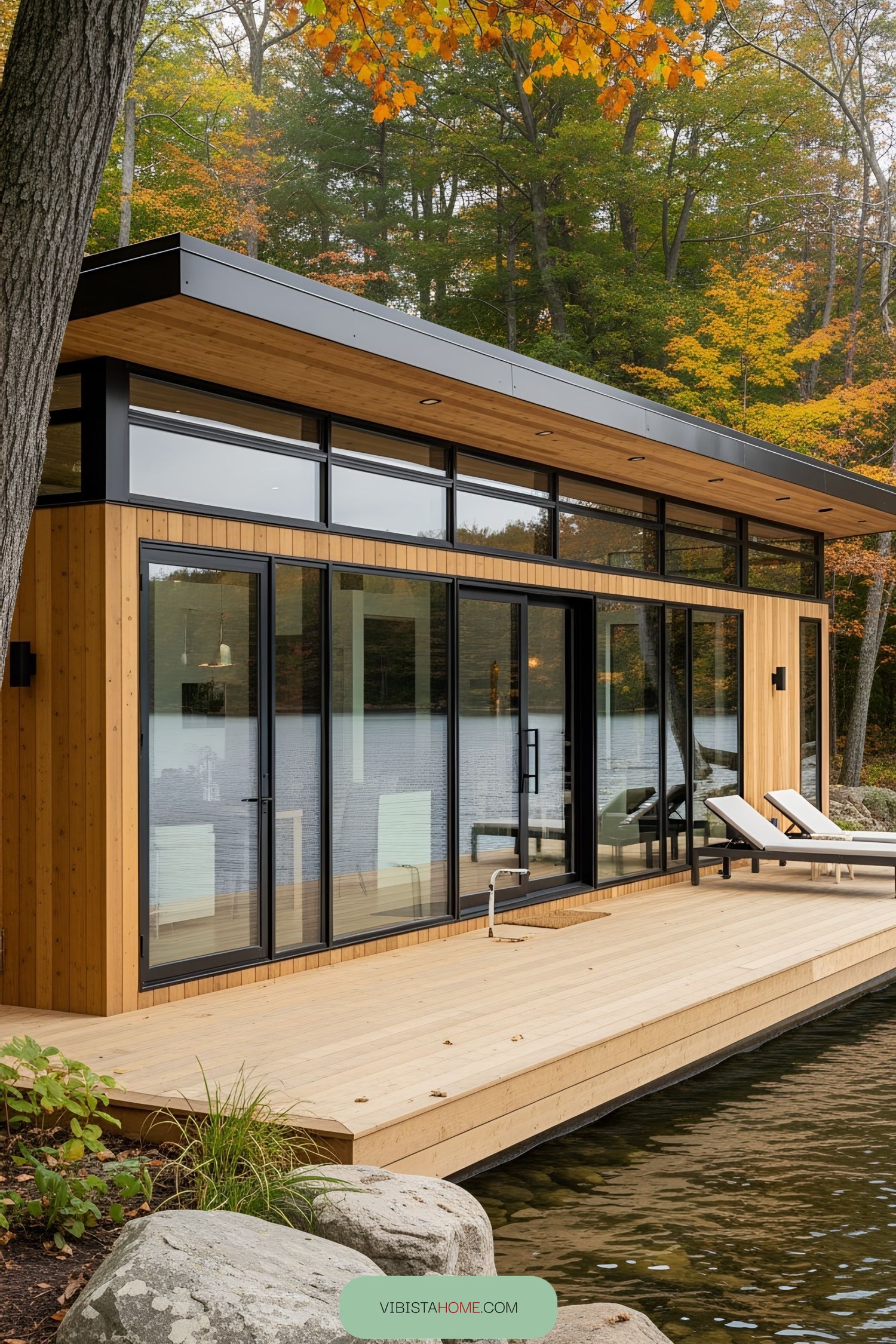 Lakefront cottage with large windows and wooden deck