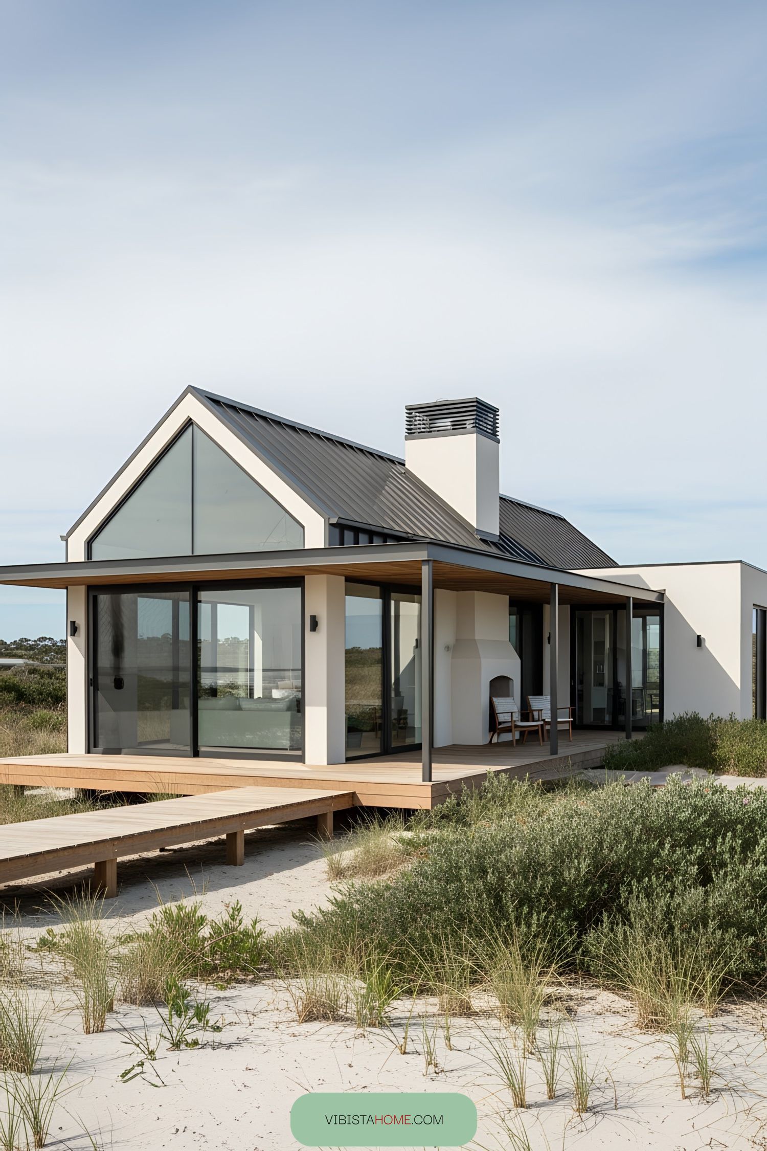 Modern bungalow with large windows and wooden deck by the beach