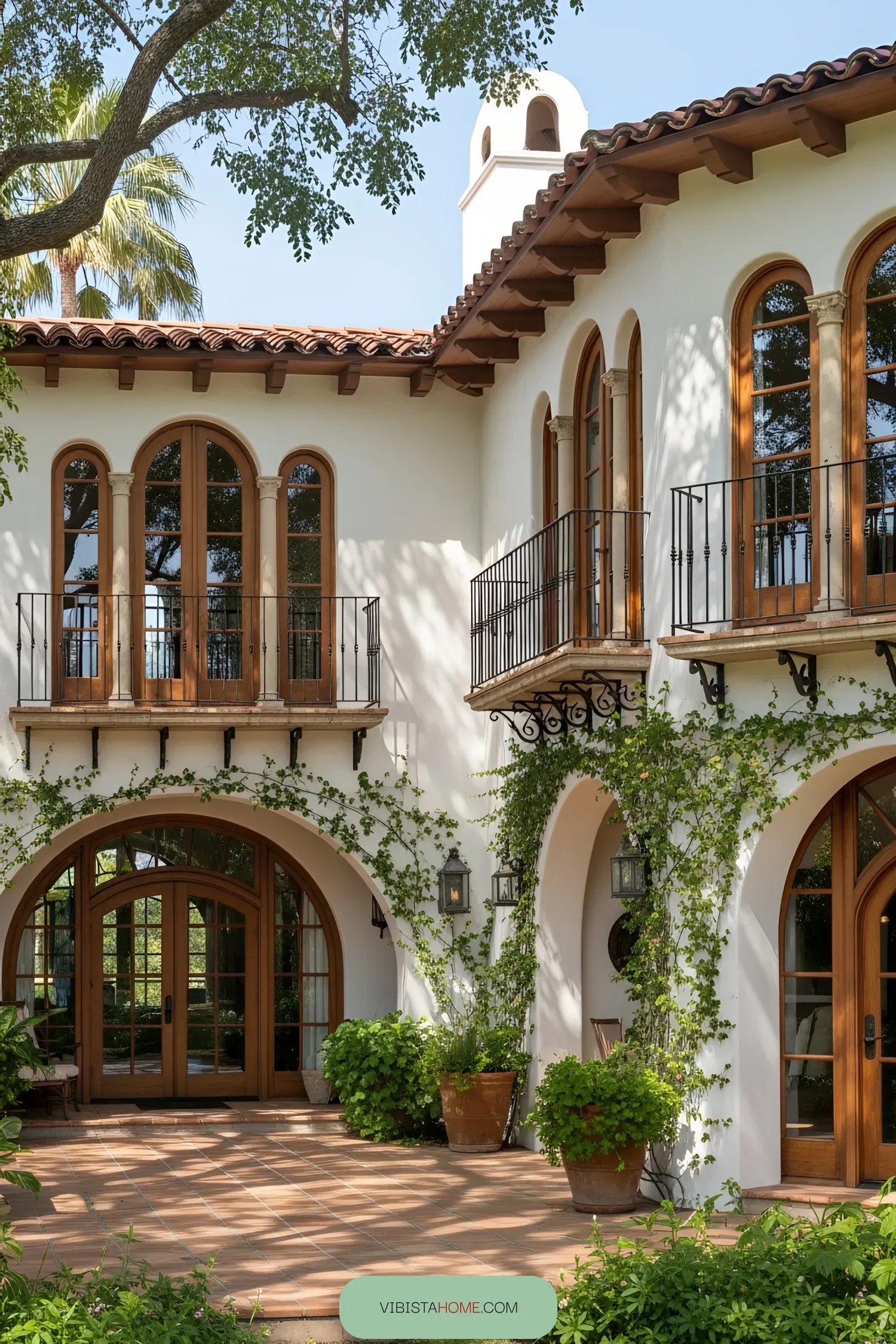 Spanish coastal house with arched windows and lush greenery