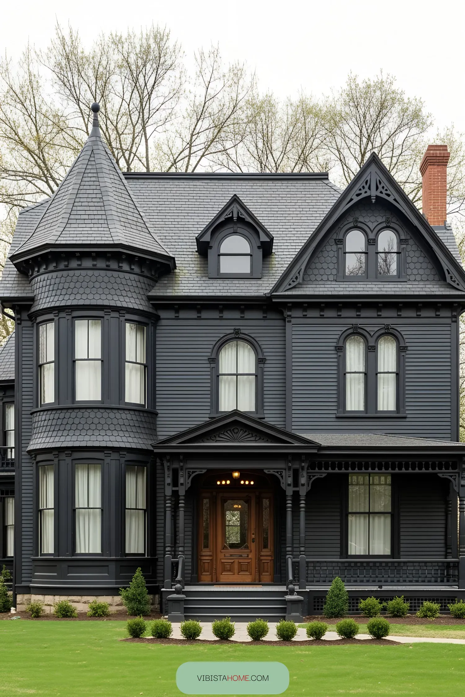 Stately black Victorian house with turret and ornate woodwork