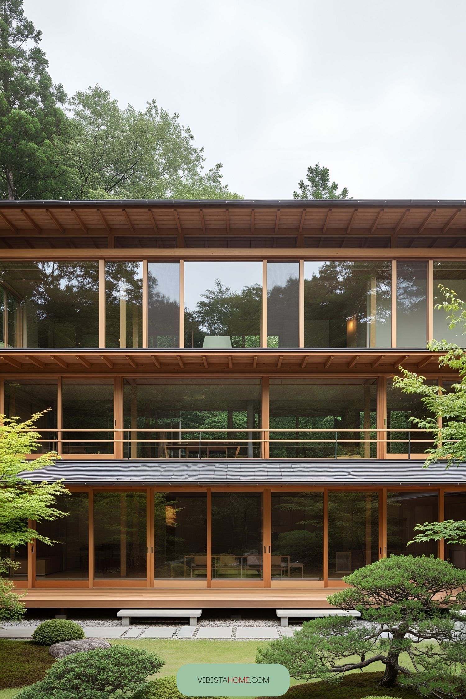 Elegant Japanese house with large glass windows surrounded by lush greenery