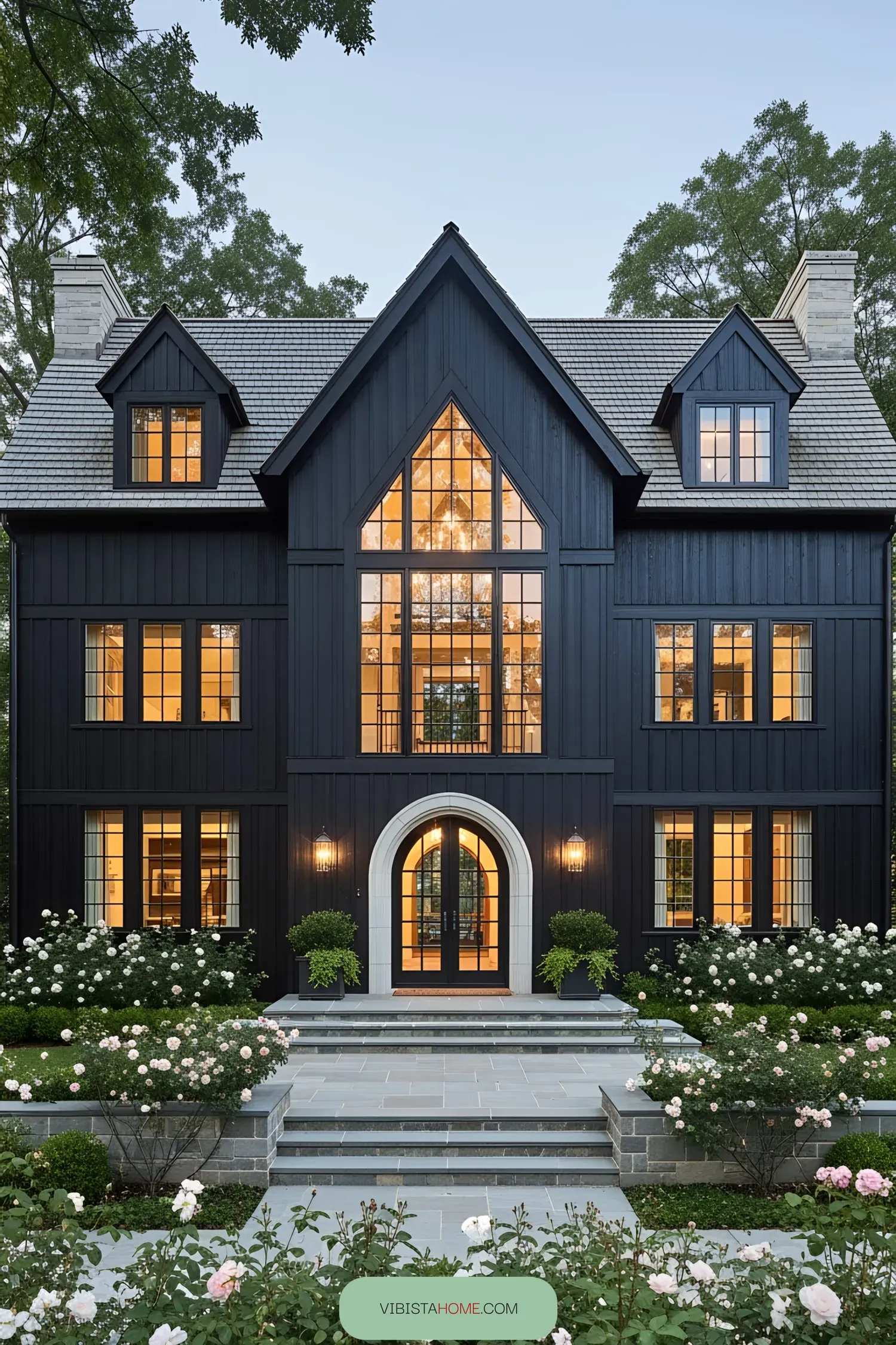 Dark coastal house with large windows and manicured garden