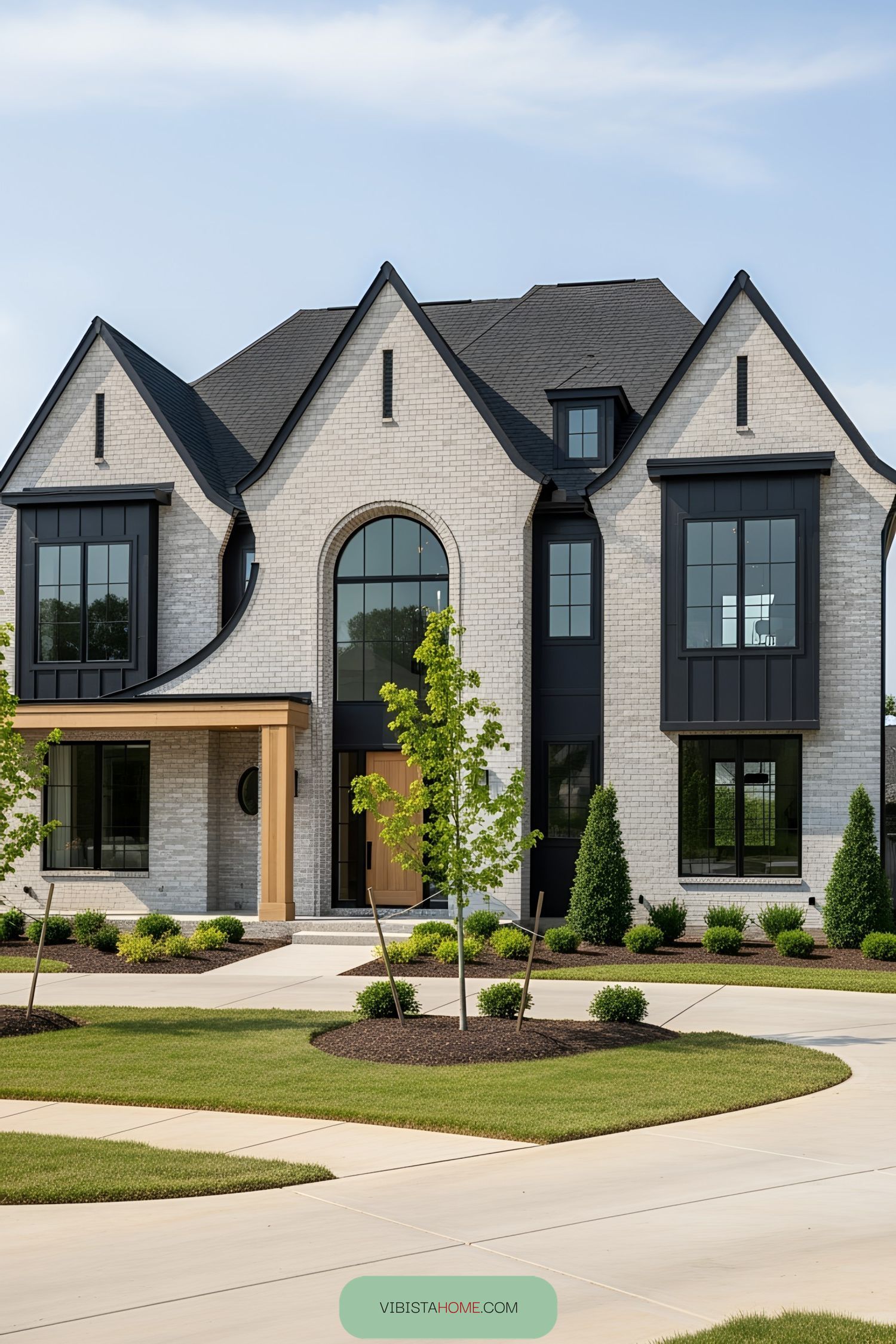 Large brick farmhouse with black accents and arched windows