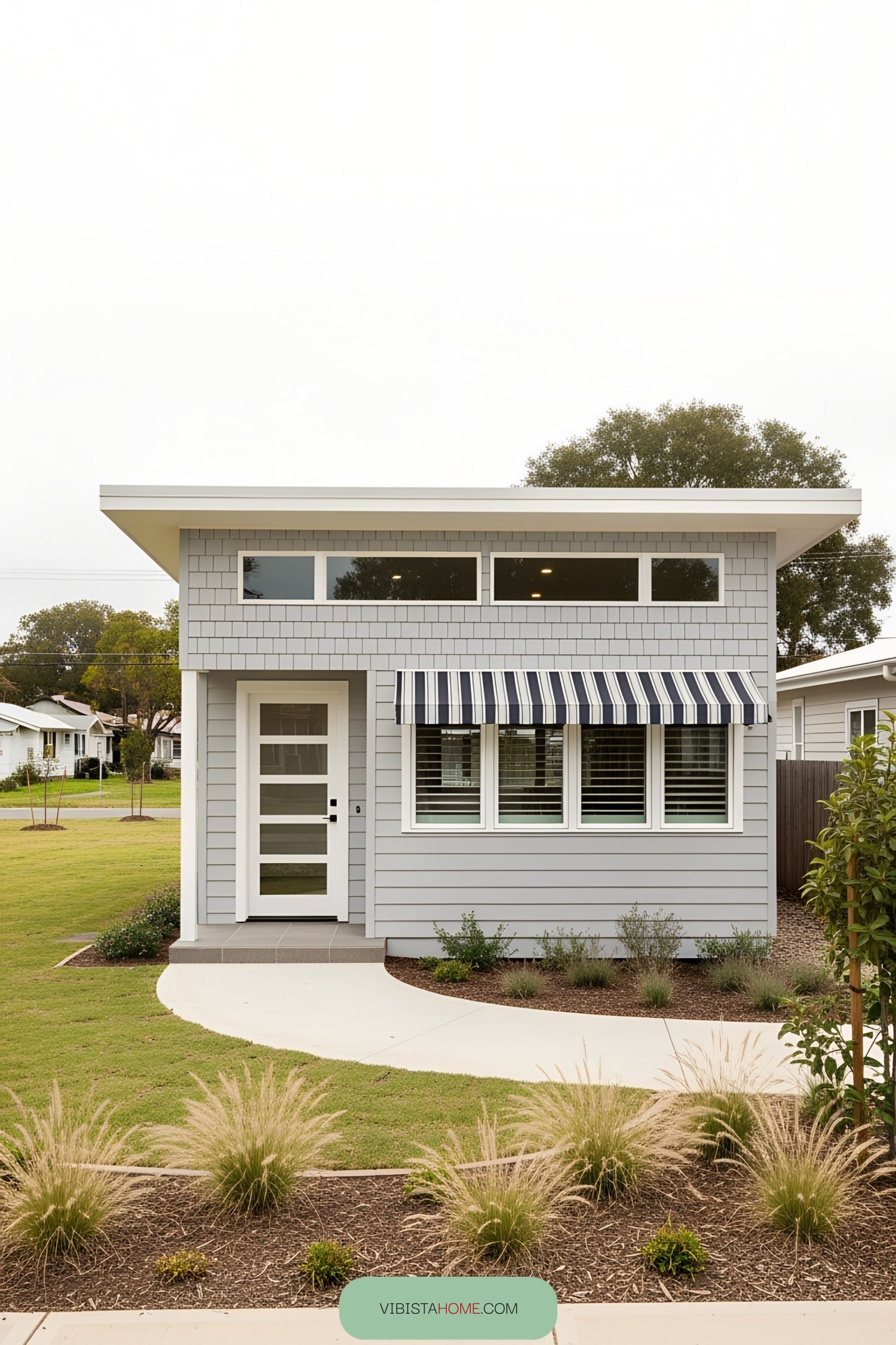 Coastal bungalow with striped awning and sleek design