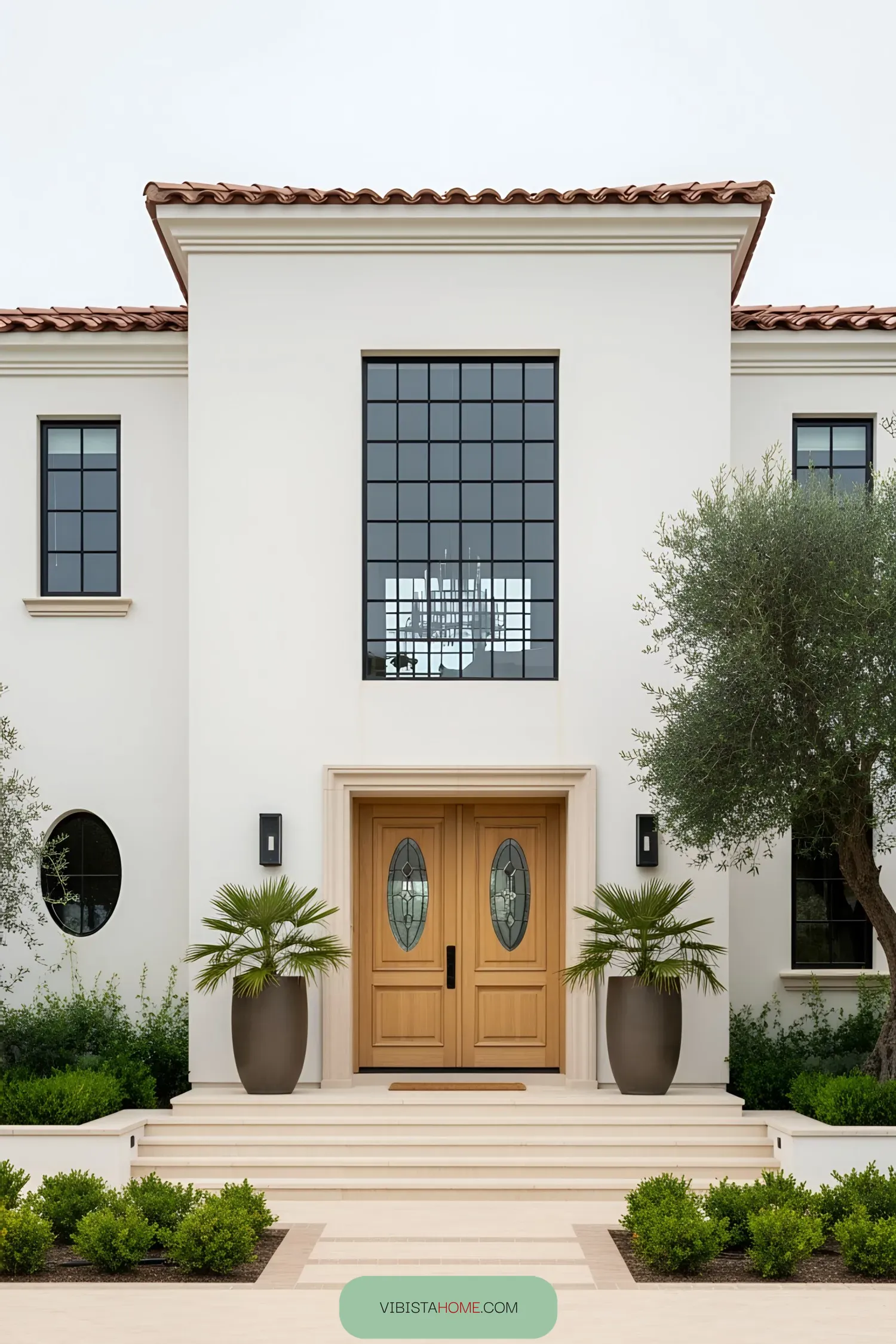 Grand wooden doors with potted palms on a Spanish coastal house