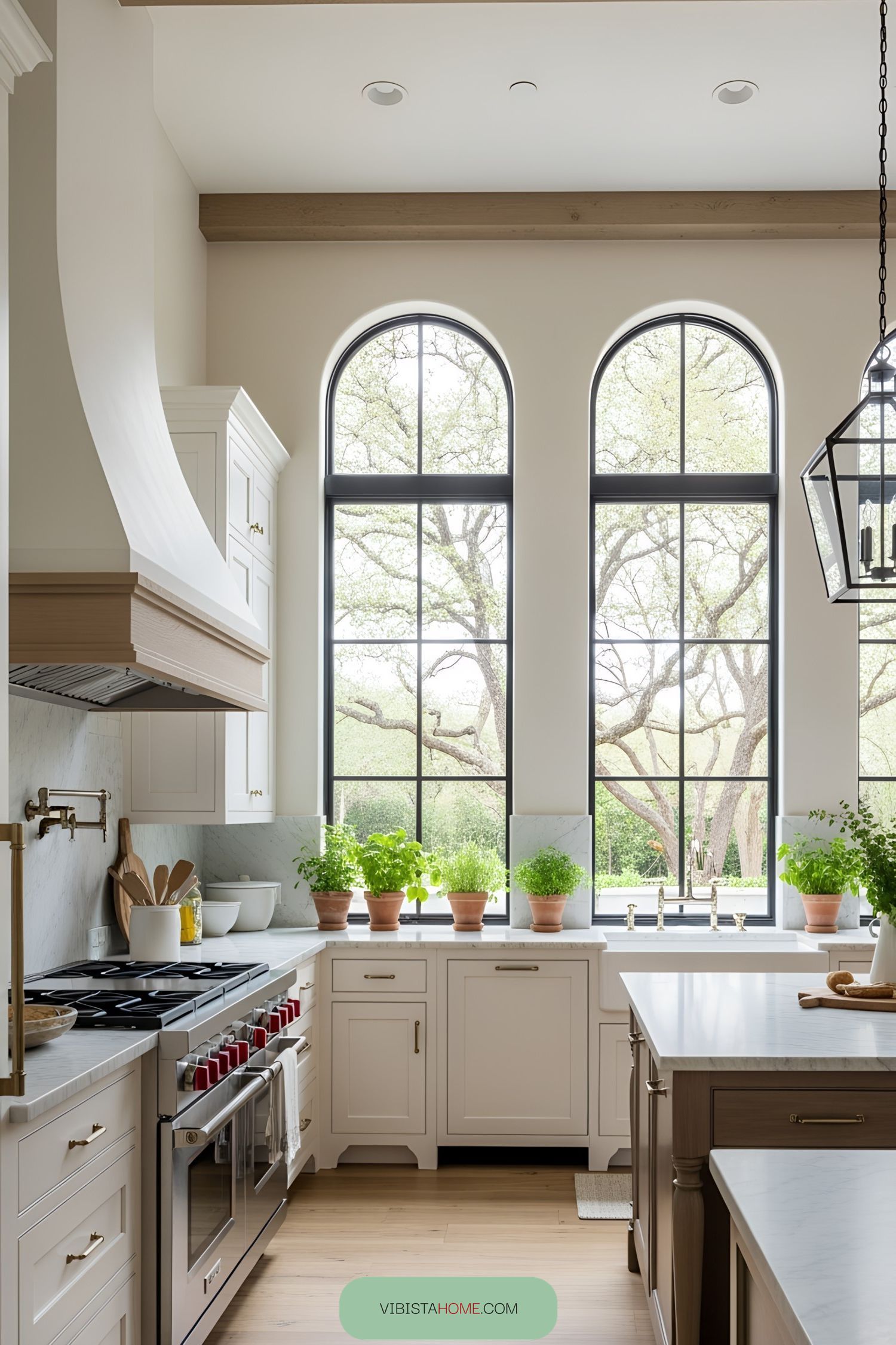 Bright and welcoming kitchen with potted herbs and large arched windows
