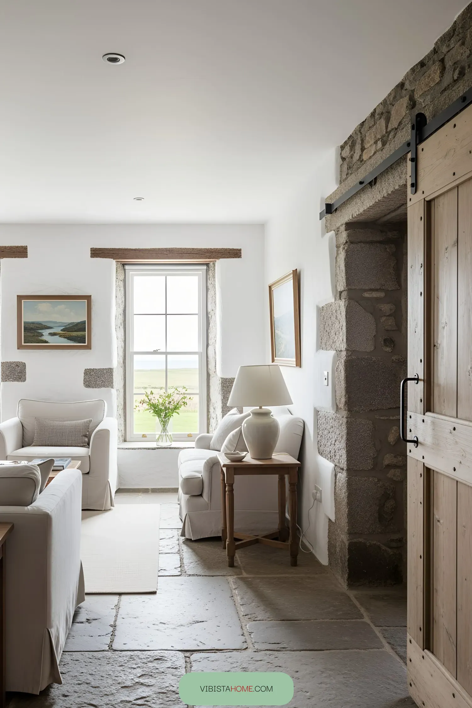 Bright living room with white sofas and stone walls