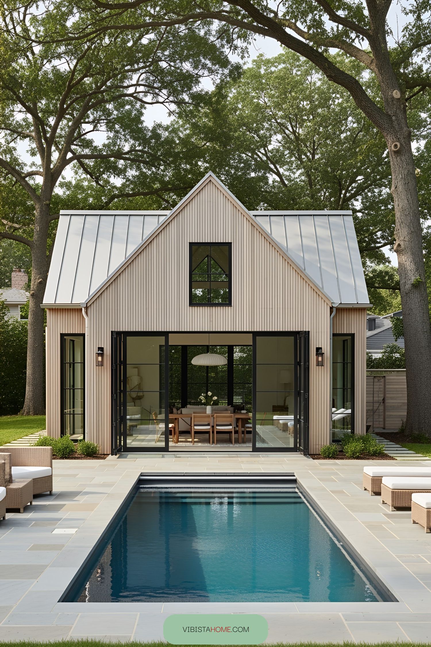 Modern barn-style pool house with glass doors and a serene pool