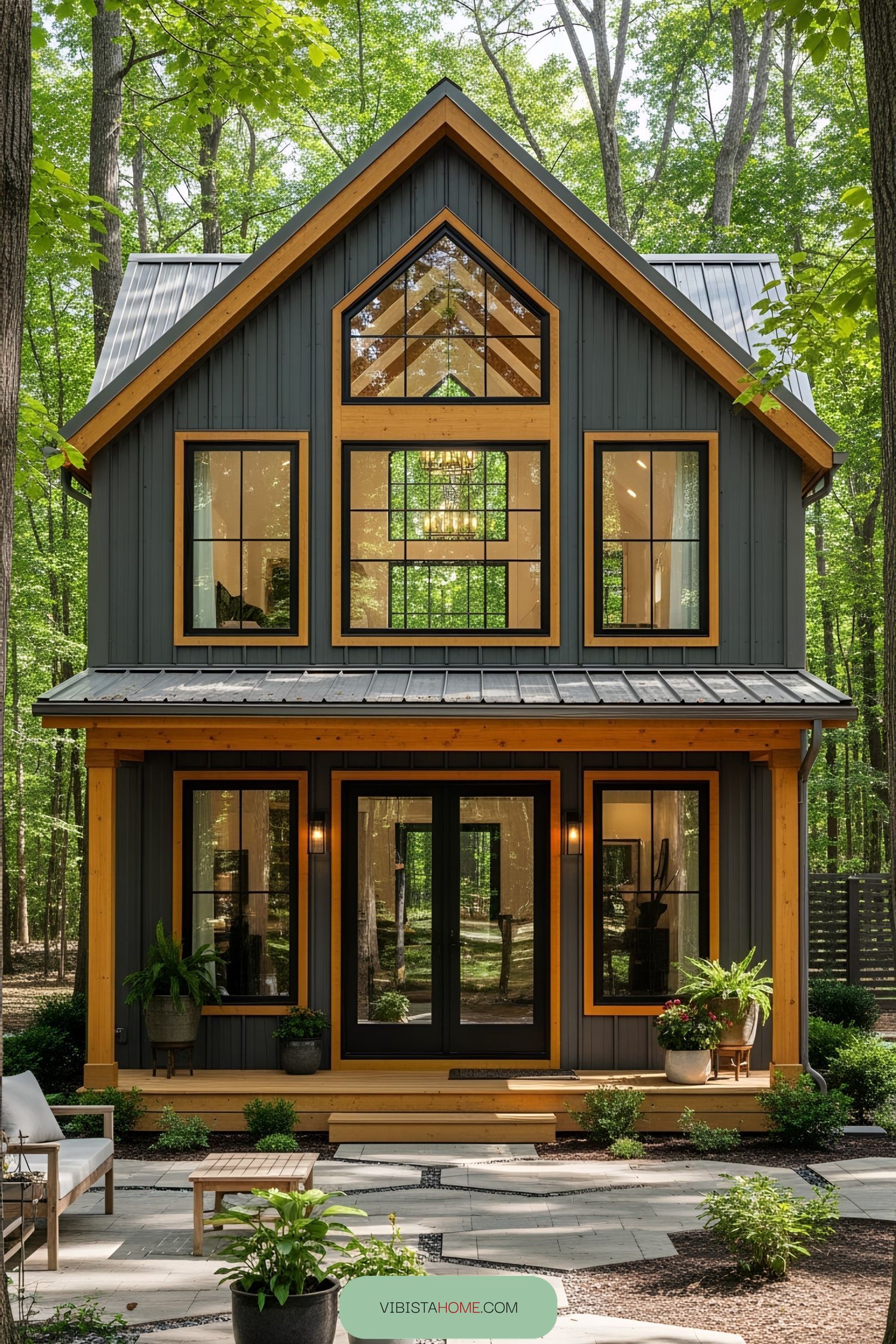 Compact barndominium with large windows surrounded by trees