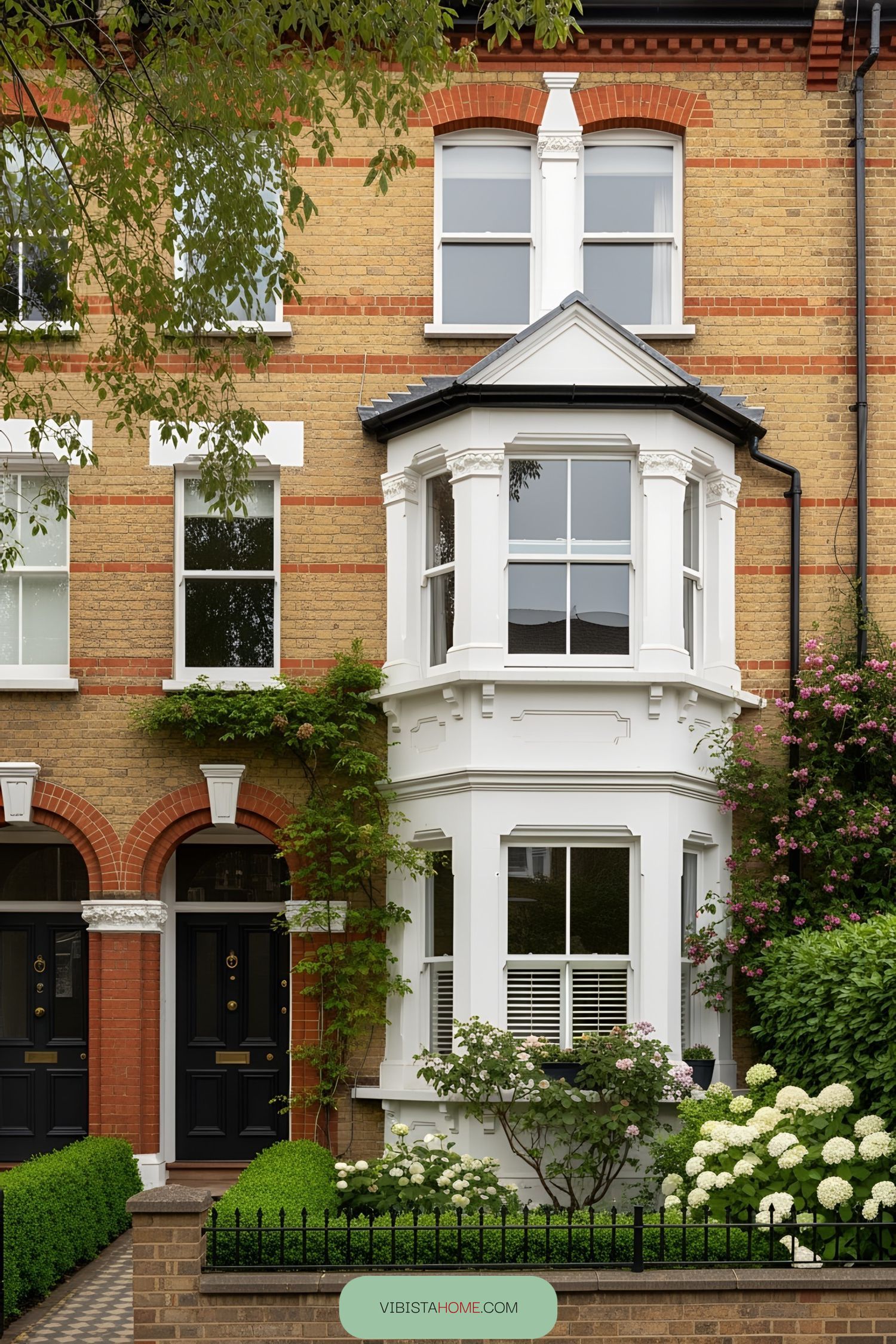 Victorian terrace house with bay windows and lush greenery