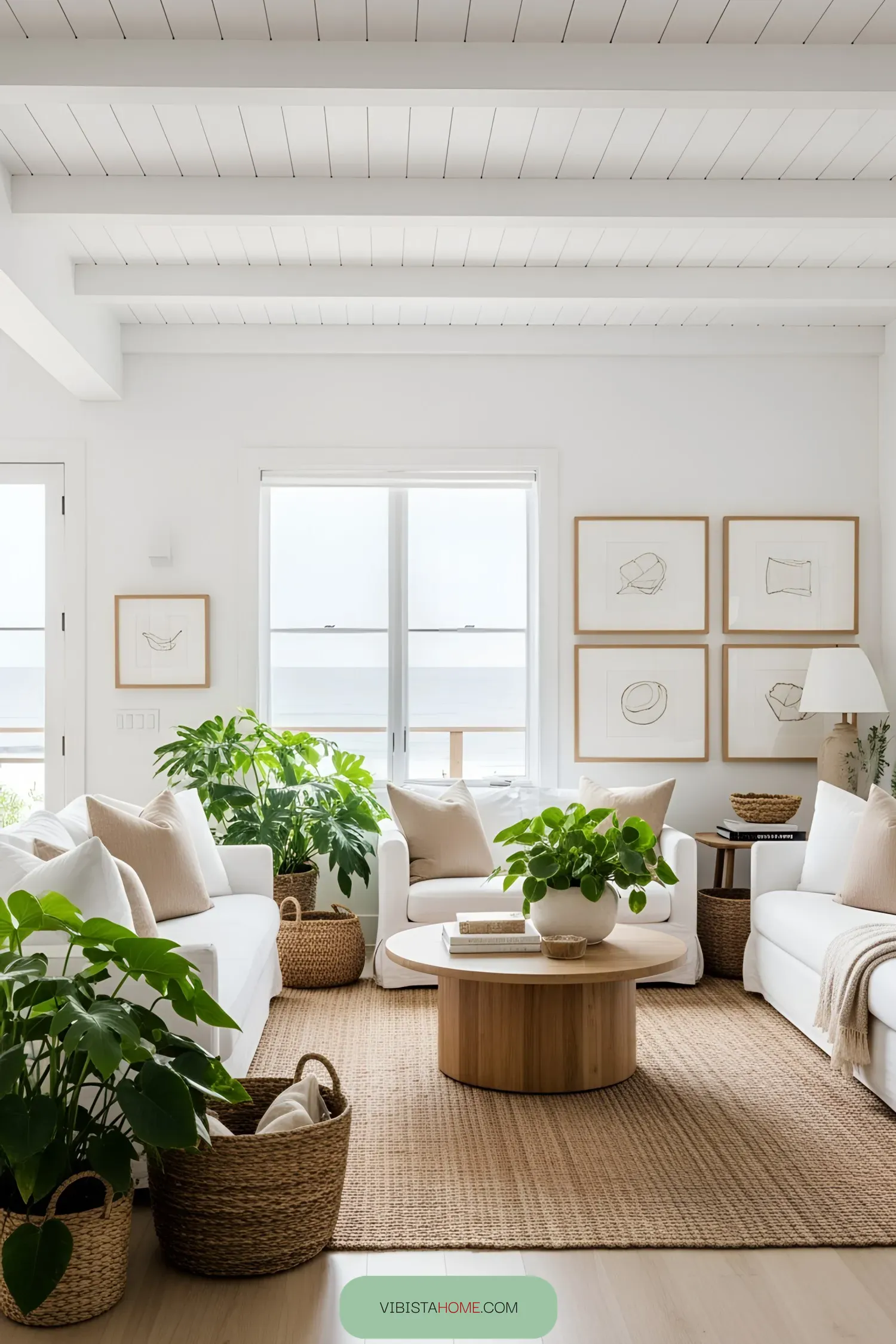 Bright beach house living room with plants and white sofas