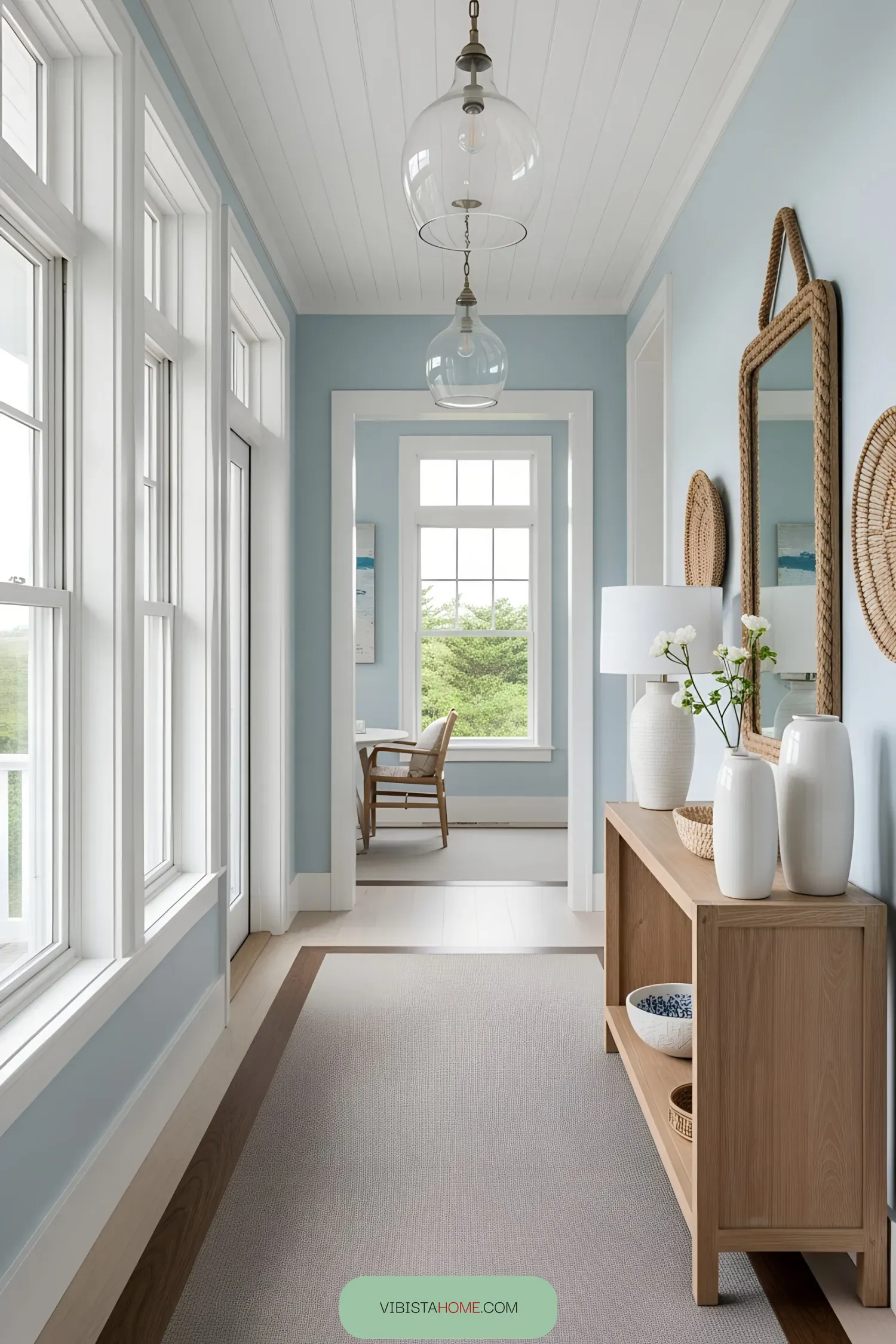 Bright hallway in a beach house with large windows and a wooden console table