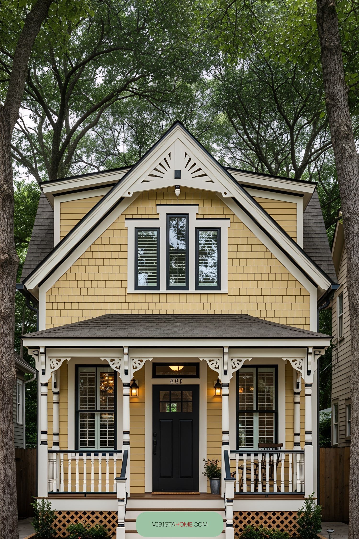 Yellow Victorian tiny house with intricate woodwork and cozy porch