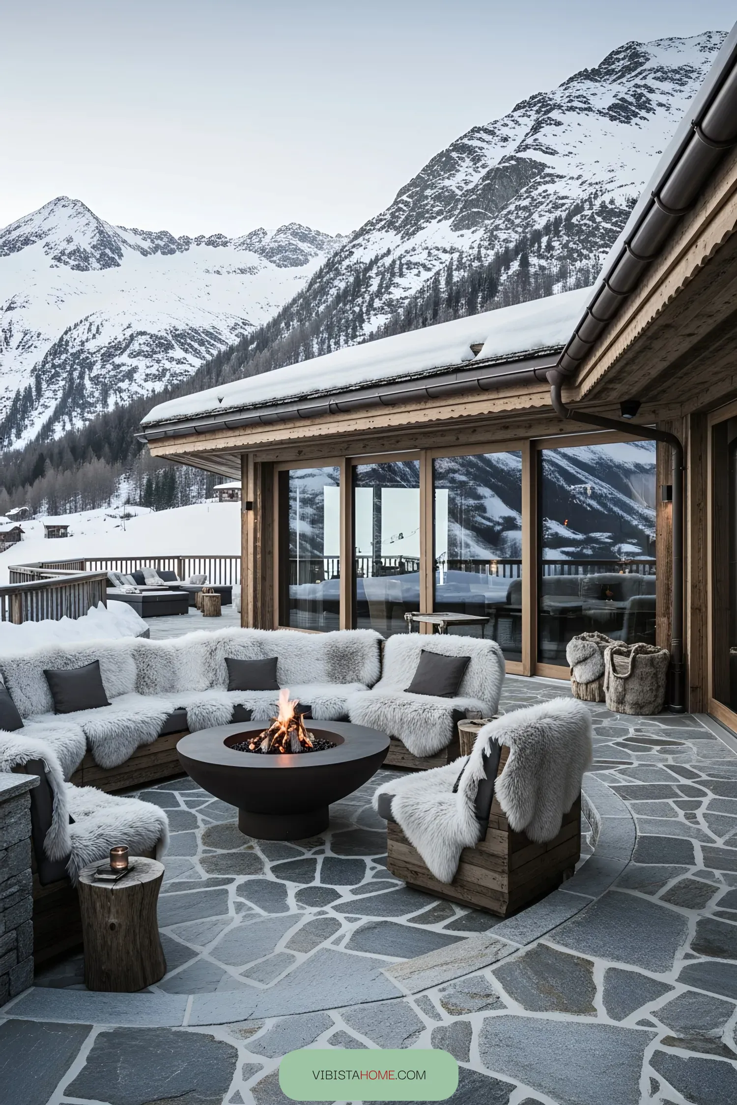 Cozy outdoor seating around a fire pit with snowy mountains in the background