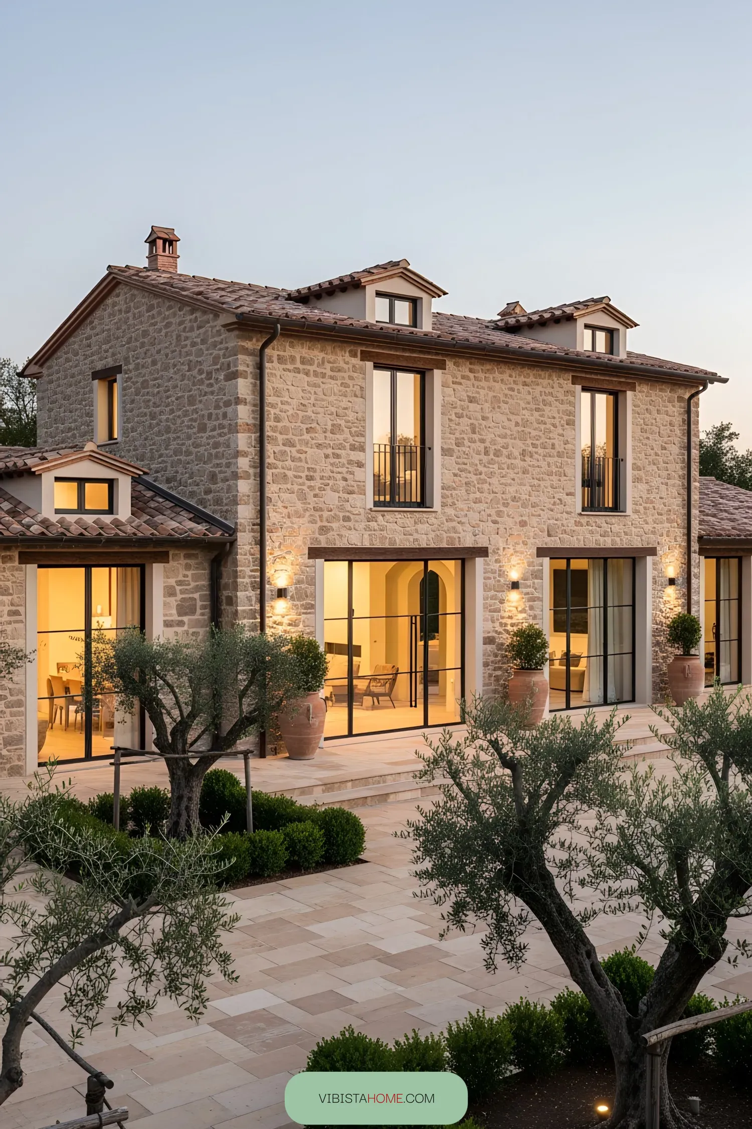 Modern Tuscan villa courtyard with stone facade and large windows
