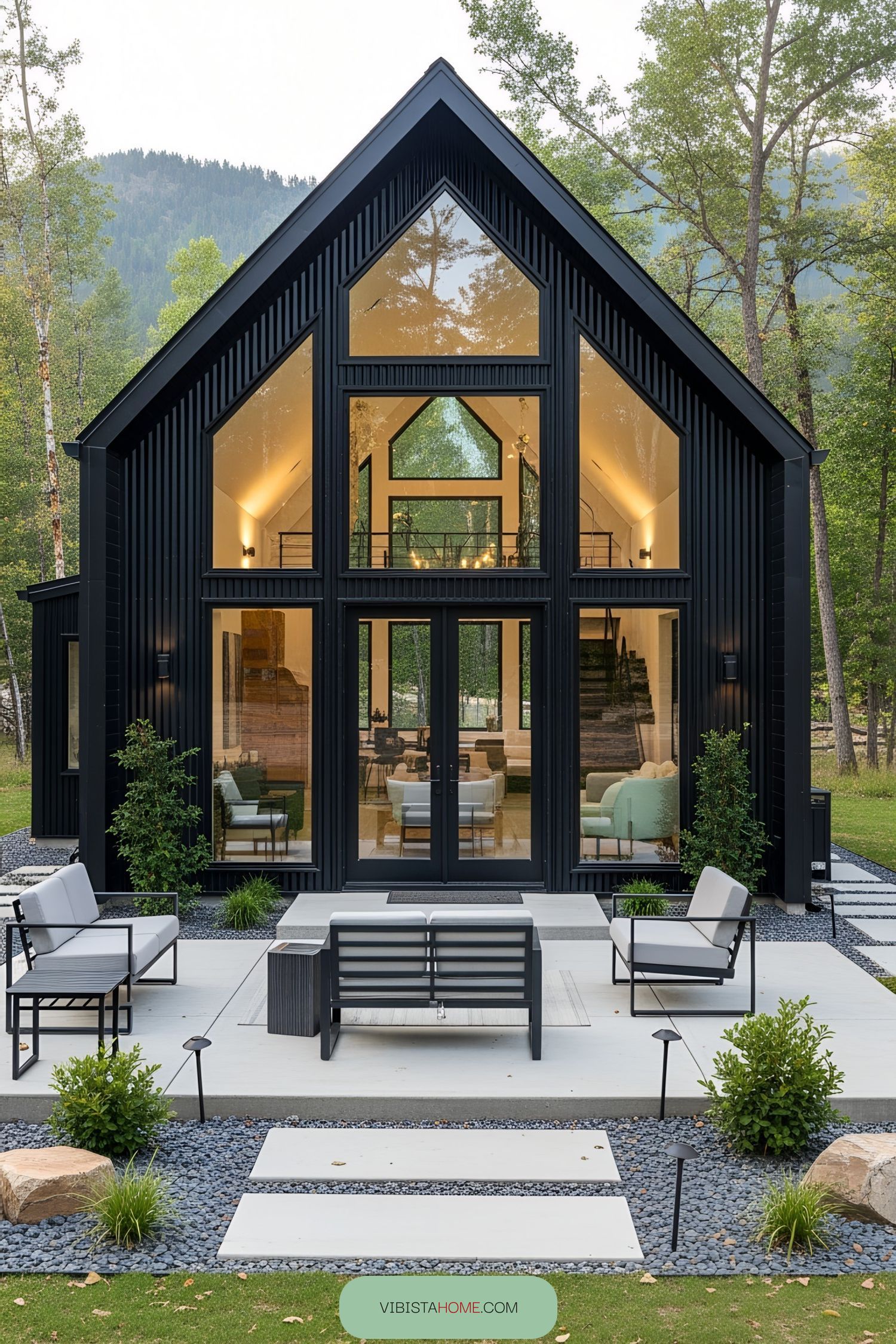 Compact black mini barndominium with large windows and outdoor seating