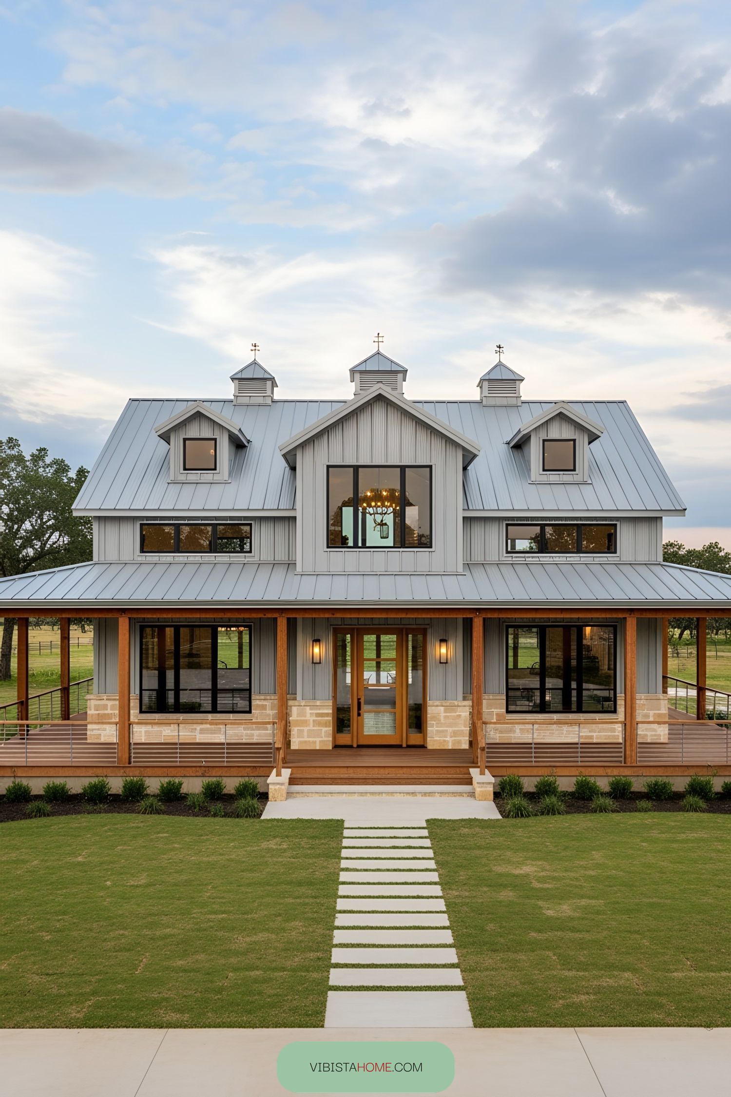 A majestic farmhouse with a metal roof and expansive porch