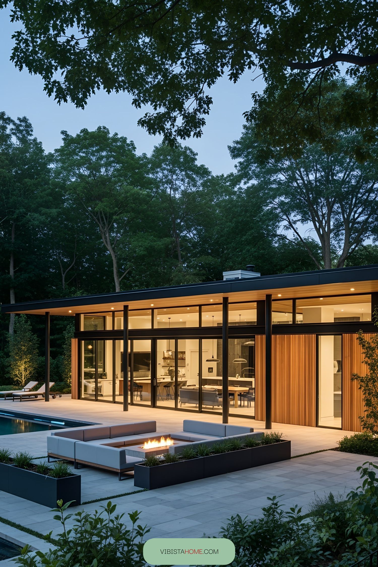 Modern pool house with large glass windows and patio furniture