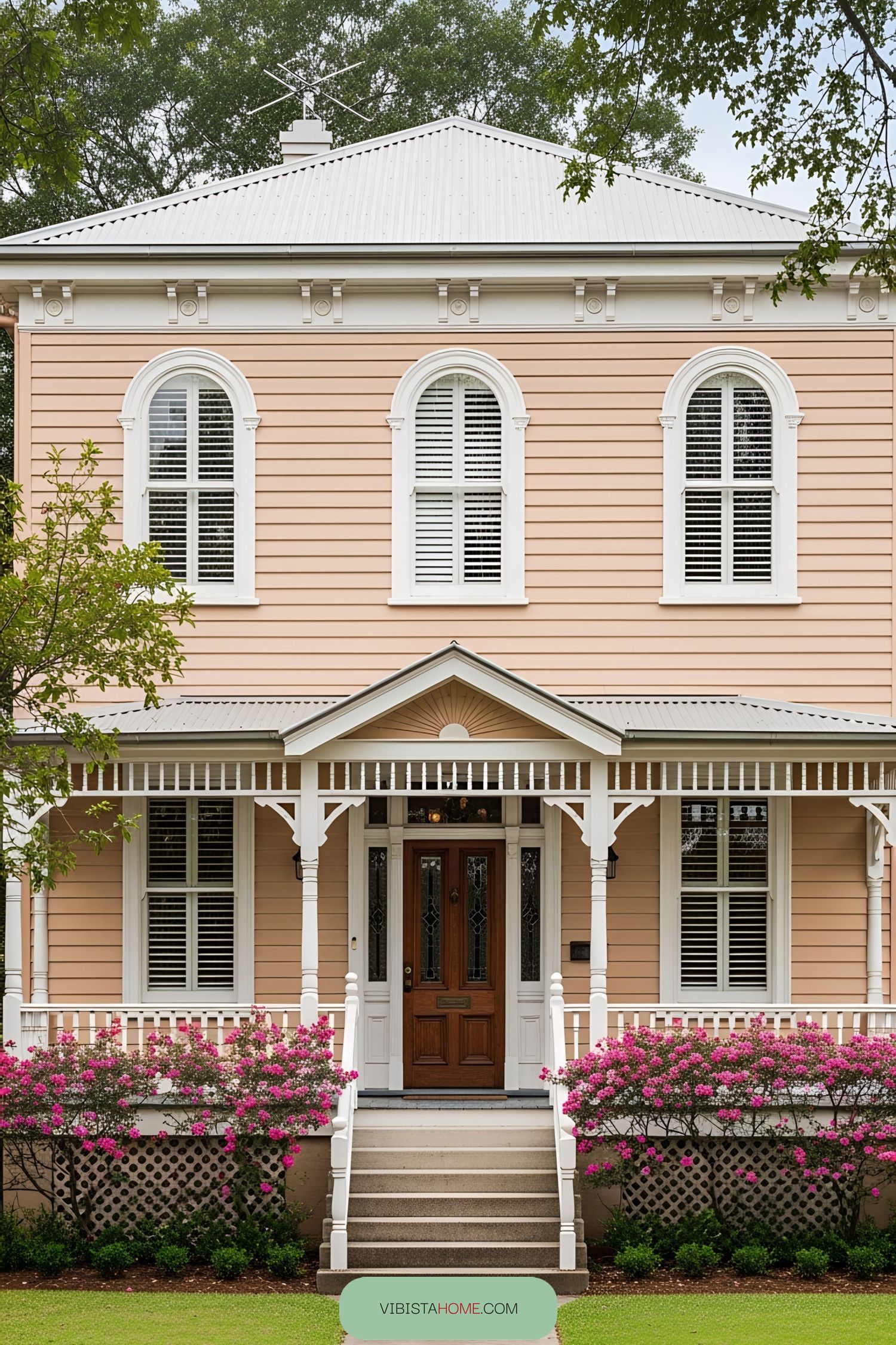 Victorian cottage with pink exterior and ornate details